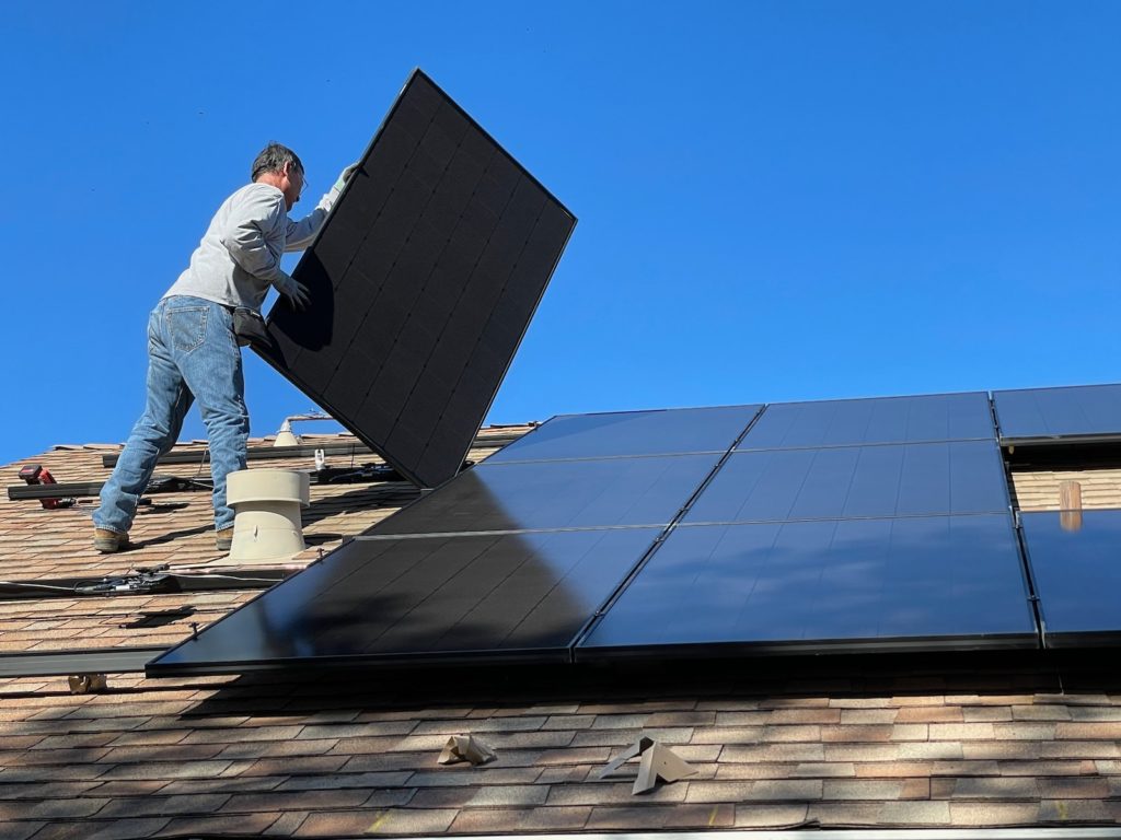 hombre instalando paneles solares en una comunidad de vecinos